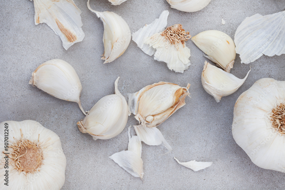 garlic bulb and cloves on rustic and mottled gray surface garlic bulb and cloves on rustic and mottled gray surface