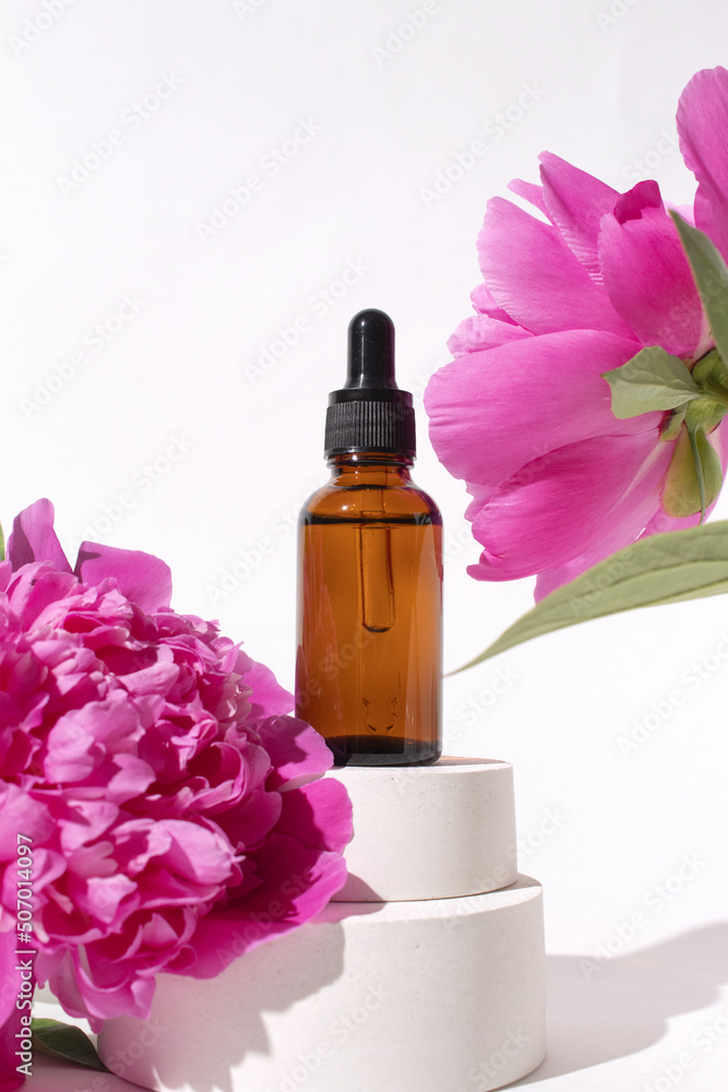 Glass dropper bottle with peony flowers. Hyaluronic acid oil, serum with collagen and peptides skin care product. Mockup packaging, cosmetic design branding Glass dropper bottle with peony flowers. Hyaluronic acid oil, serum with collagen and peptides skin care product. Mockup packaging, cosmetic design branding