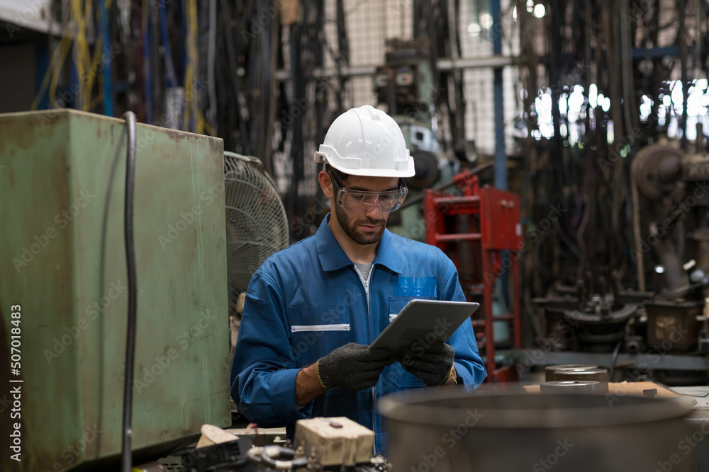 Engineer male worker maintaining machine lathe metal at the industry factory. Factory worker maintenance electronics of machine in industry factory Engineer male worker maintaining machine lathe metal at the industry factory. Factory worker maintenance electronics of machine in industry factory