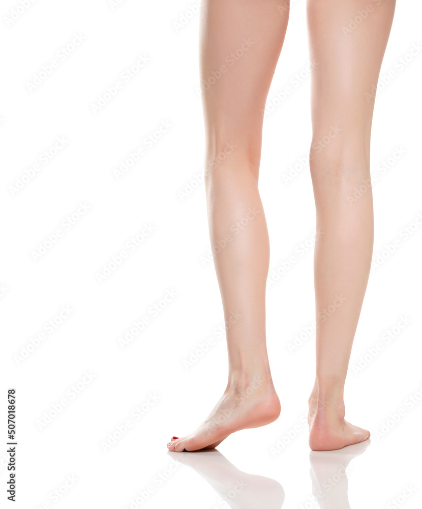 Rear view of beautifully cared women's legs and knees on white background