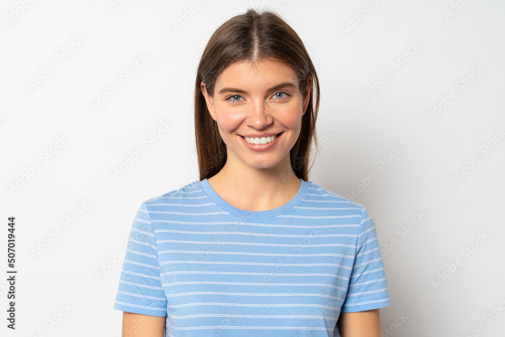 Pretty joyful woman in blue t-shirt isolated over white blank studio wall Pretty joyful woman in blue t-shirt isolated over white blank studio wall