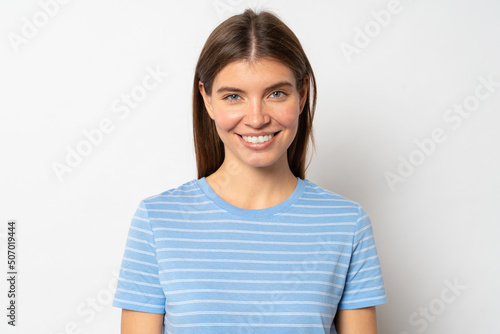 Pretty joyful woman in blue t-shirt isolated over white blank studio wall © Damir Khabirov
