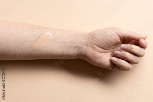 Foundation cream smear test on female hand, CC cream stroke, tinted moisturiser applied on woman hand