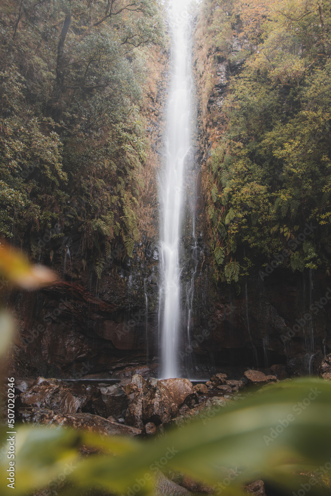 In rainy weather, the majestic and well-known 25fontes waterfall rises in the mist and rain on the island of Madeira, Portugal. Discovering magical places in Europe