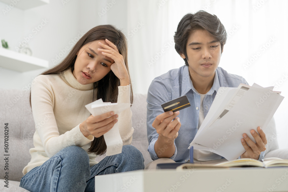 Stressed financial owe asian young couple love sitting suffer, stressed and confused by calculate expense from invoice or bill, no money to pay, mortgage or loan. Debt, bankrupt or bankruptcy people. Stressed financial owe asian young couple love sitting suffer, stressed and confused by calculate expense from invoice or bill, no money to pay, mortgage or loan. Debt, bankrupt or bankruptcy people.