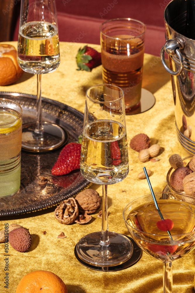Valdobbiadene Prosecco flutes, a bottle, cocktails and fruit on a luxury colorful table. Prosecco is an italian sparkling wine cultivated and produced in Valdobbiadene area. Vintage mood