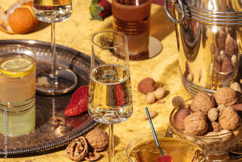 Valdobbiadene Prosecco flutes, a bottle, cocktails and fruit on a luxury colorful table. Prosecco is an italian sparkling wine cultivated and produced in Valdobbiadene area. Vintage mood