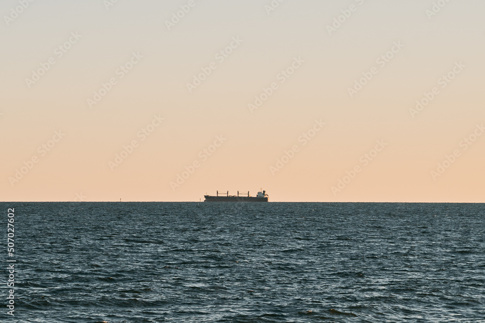 Distant ship over horizon. Commercial vessel in the Baltic Sea