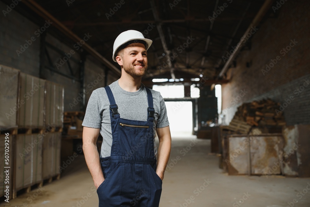 Portrait of happy male worker in warehouse standing between shelves. Portrait of happy male worker in warehouse standing between shelves.