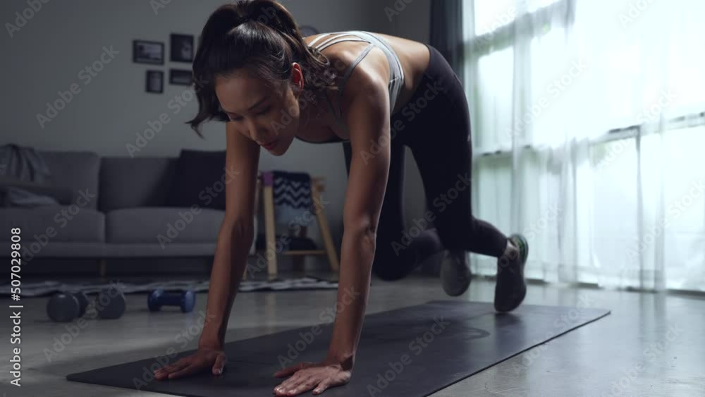 Training at home concept. Happy sporty Asian woman doing exercise, young female exercising in living room. Training at home concept. Happy sporty Asian woman doing exercise, young female exercising in living room.