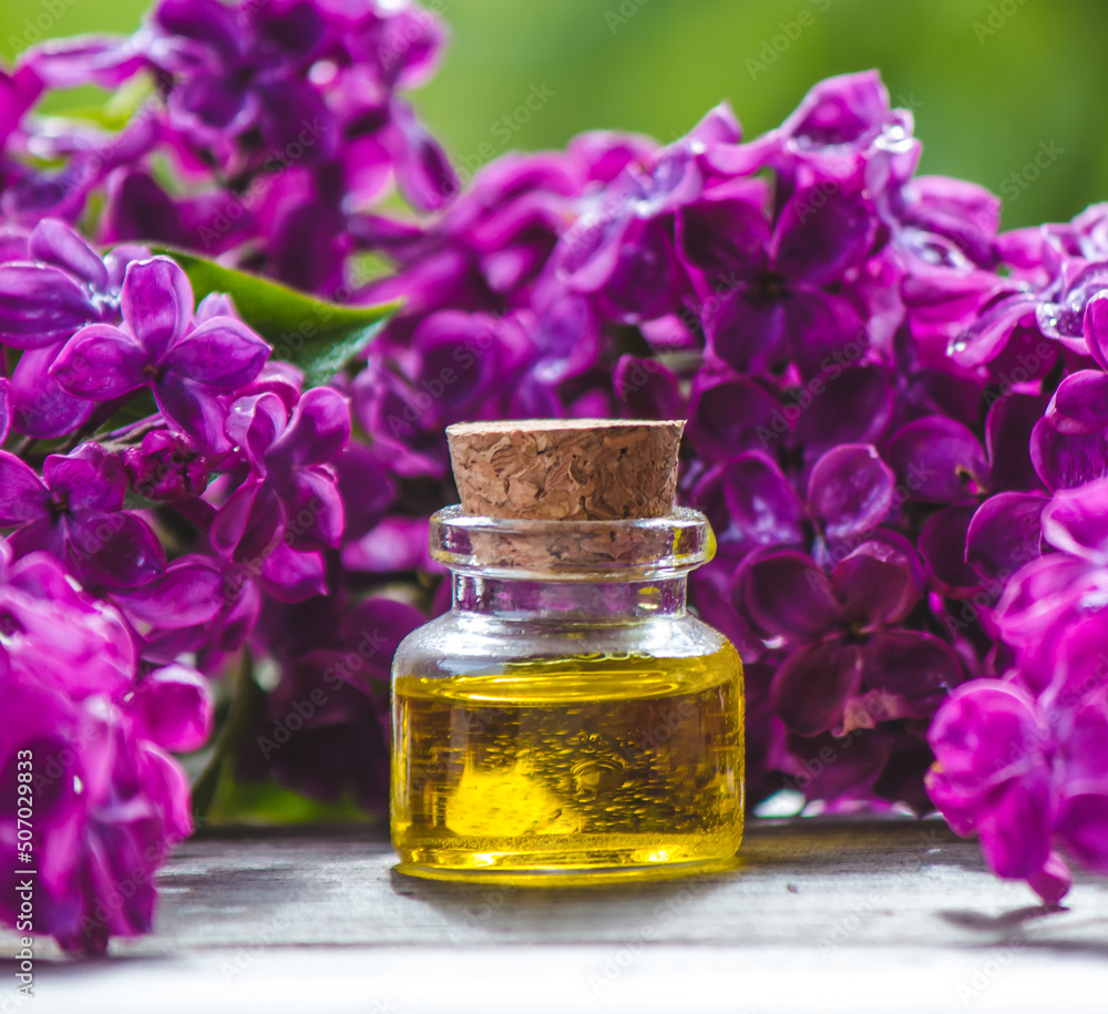 Lilac essential oil in a small bottle. Selective focus. Lilac essential oil in a small bottle. Selective focus.