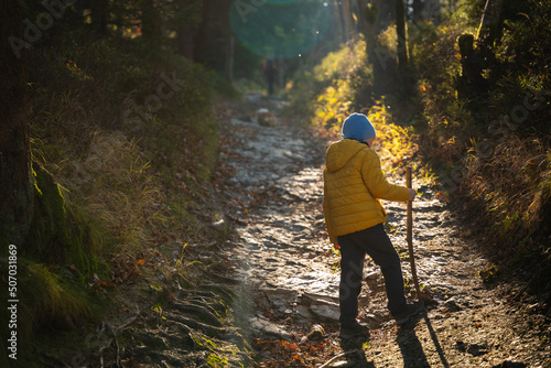 The little kid is walking the mountain trail. Fall season © Piotr