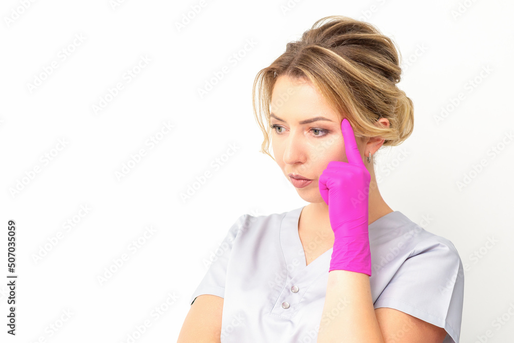 Young caucasian female doctor wearing gloves thoughtful looking away isolated on white background Young caucasian female doctor wearing gloves thoughtful looking away isolated on white background