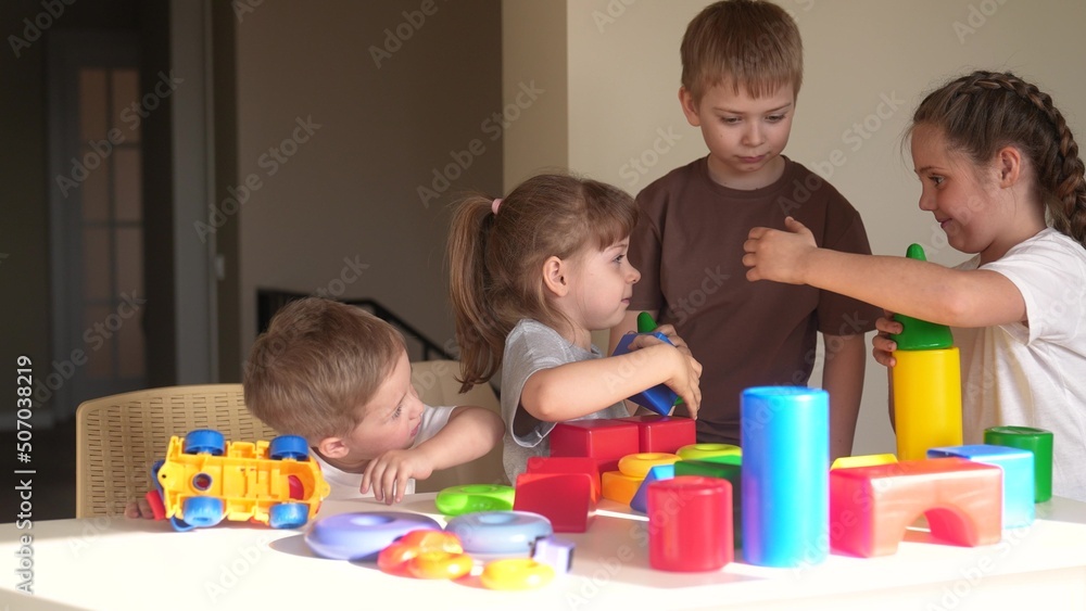 kindergarten. a group of children play toys cubes and cars indoor on the table in kindergarten. kid dream creative happy family preschool education concept. nursery baby toddler home kindergarten. a group of children play toys cubes and cars indoor on the table in kindergarten. kid dream creative happy family preschool education concept. nursery baby toddler home