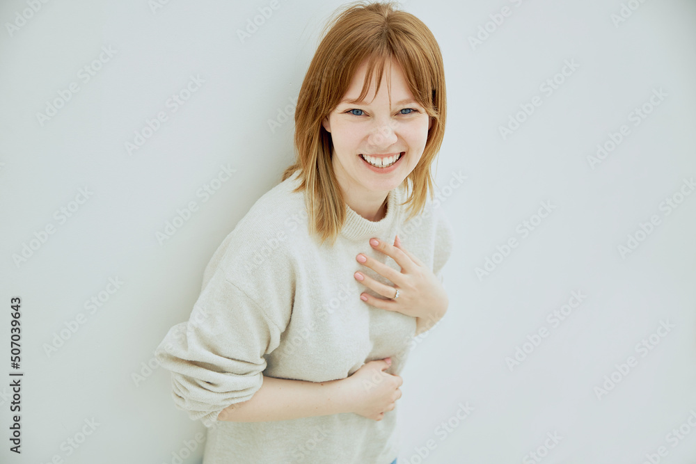 Portrait of young red haired cheerful girl smiling looking at camera over white background. Portrait of young red haired cheerful girl smiling looking at camera over white background.