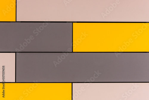 Facade of a modern building covered with yellow and gray plates