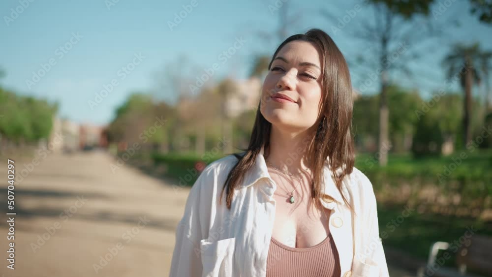 Pretty brunette woman looking around and walking in the park Pretty brunette woman looking around and walking in the park