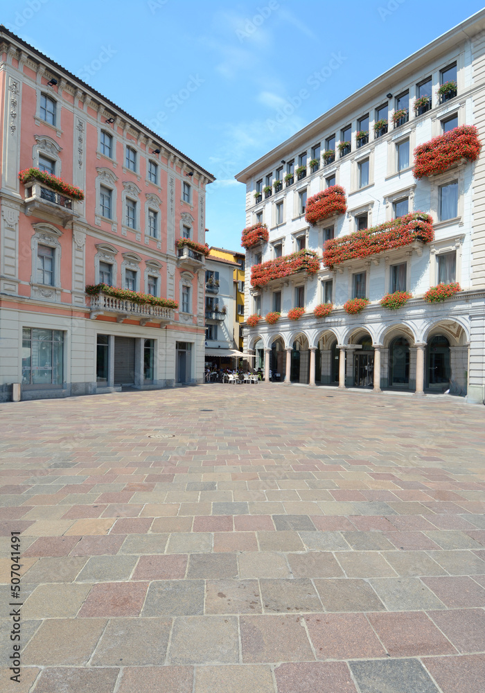 Switzerland / Lugano  - July 28, 2018: elegant buildings with arcades and cafes in the central Piazza Riforma in Lugano