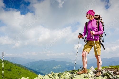 Woman Traveler with Backpack hiking in the Mountains
