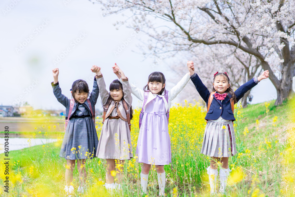 Naklejka premium お花畑で仲良く遊ぶ小学生の女の子