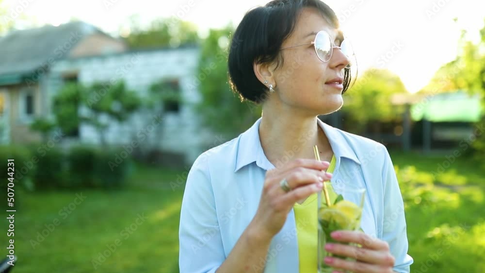 Woman drinking summer citrus lemonade with reusable metal straws party in a backyard house with cold drink, summertime, eco friendly drinking straw, Healthy lifestyle, vegetarian food, detox water Woman drinking summer citrus lemonade with reusable metal straws party in a backyard house with cold drink, summertime, eco friendly drinking straw, Healthy lifestyle, vegetarian food, detox water