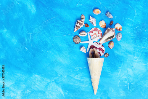 Seashells in a waffle cone on blue