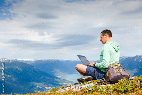 man working outdoors with laptop