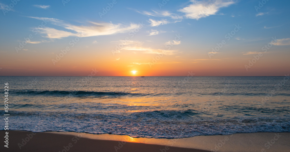 Panoramic beach and sea view with beautiful sunrise during golden hour.