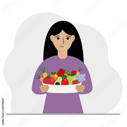 A woman with a large plate of healthy organic food - vegetables and fruits. The concept of healthy food, healthy lifestyle, vegetarianism, agriculture.