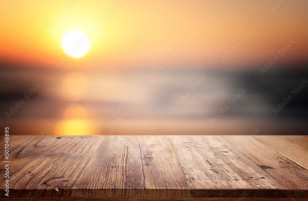 Wooden table and blurred sunset background. Summertime and vacation Wooden table and blurred sunset background. Summertime and vacation