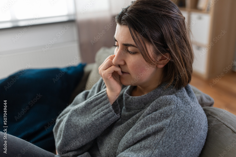 mental health, psychological problem and depression concept - stressed woman sitting on sofa at home mental health, psychological problem and depression concept - stressed woman sitting on sofa at home