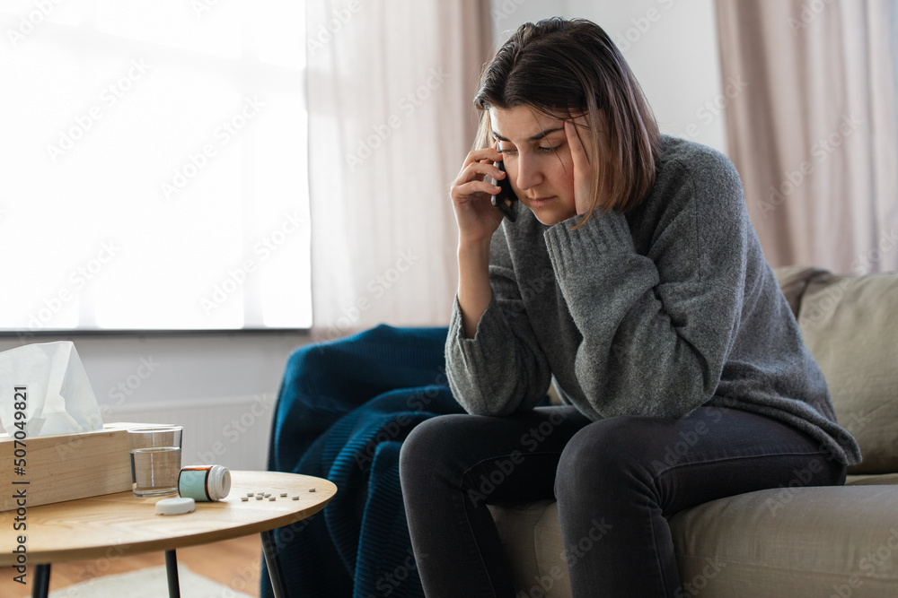 mental health, psychological help and depression concept - stressed woman with sedative medicine on table calling on phone at home - obrazy, fototapety, plakaty 