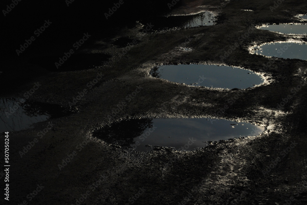 dirt road, bumpy and full of holes, and these holes full of water - obrazy, fototapety, plakaty 