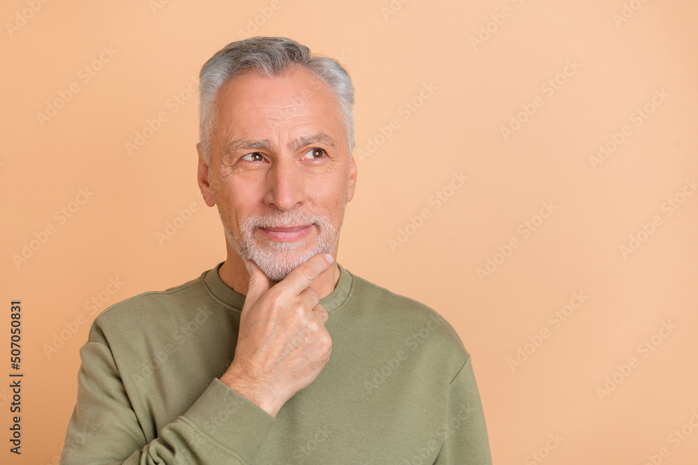 Photo of senior man hand touch chin wonder think look empty space isolated over beige color background Photo of senior man hand touch chin wonder think look empty space isolated over beige color background