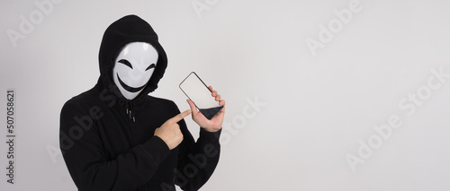 Fotografija Anonymous hacker and face mask with smartphone in hand