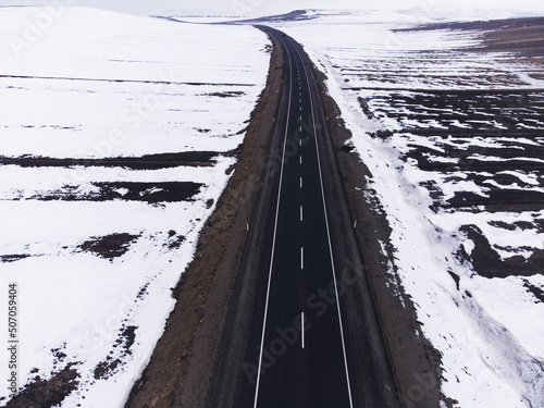 Aerial view of a road with one lane and snow in winter photo