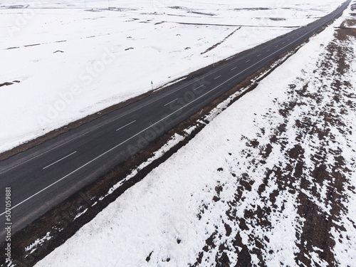 Aerial diagonal view of a road with one lane and snow in winter photo