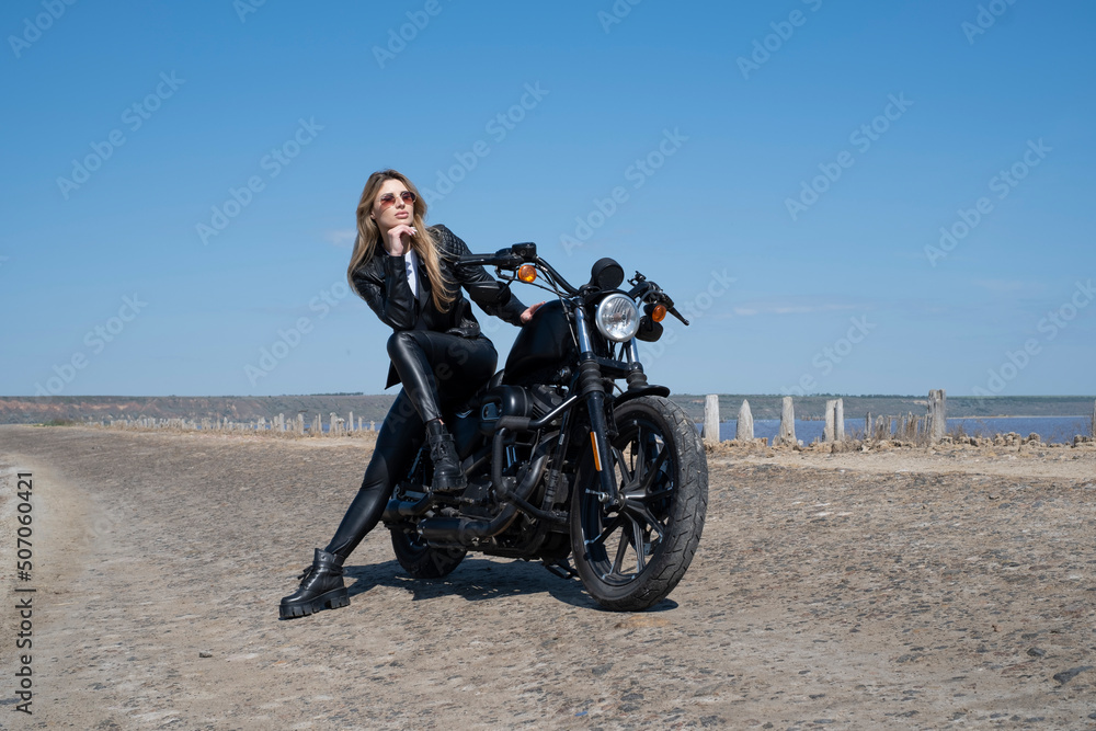 Obraz premium beautiful girl in leather clothes sitting on a motorcycle