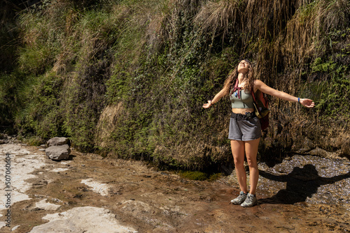 woman with open arms looking at the sky on the mountain