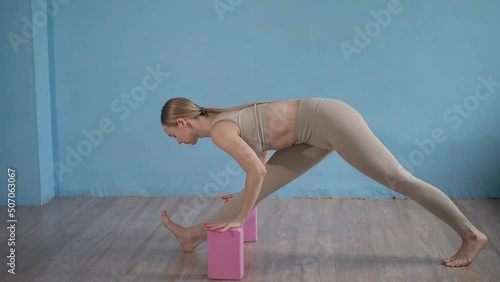 deushka makes stretching using pink blocks for support photo