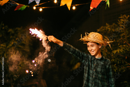 Child playing with fireworks during the traditional Festa Junina in Brazil. photo