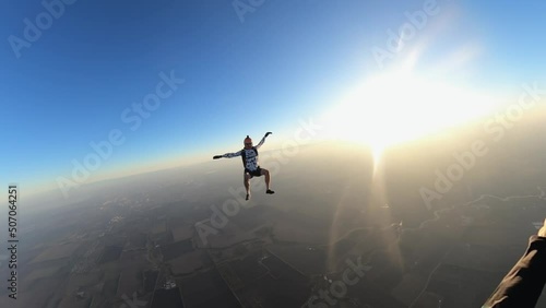 skydiving, acrobatics in the sky, a man in free fall, parachutists fall at sunset