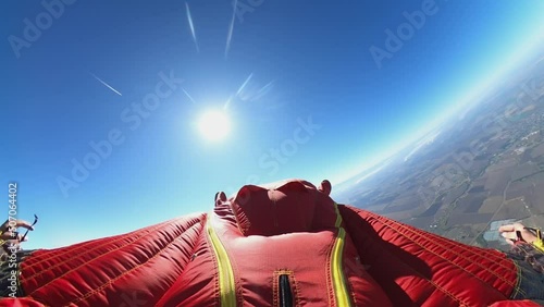 a man flies in a wingsuit suit in a clear sky in sunny weather photo