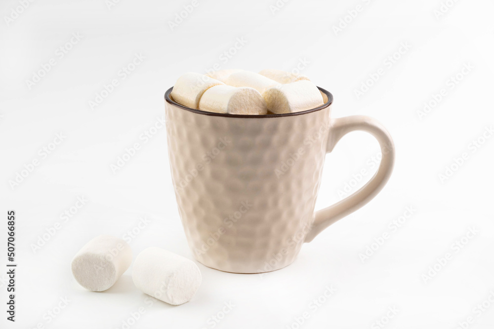 On a white background, a beige cup with cocoa and marshmallows. On a white background, a beige cup with cocoa and marshmallows.