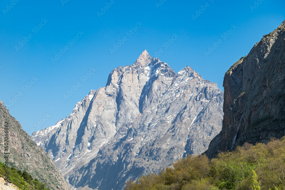 Rocky peak in a narrow mountain gorge on a sunny day. Mountains of Kyrgyzstan.