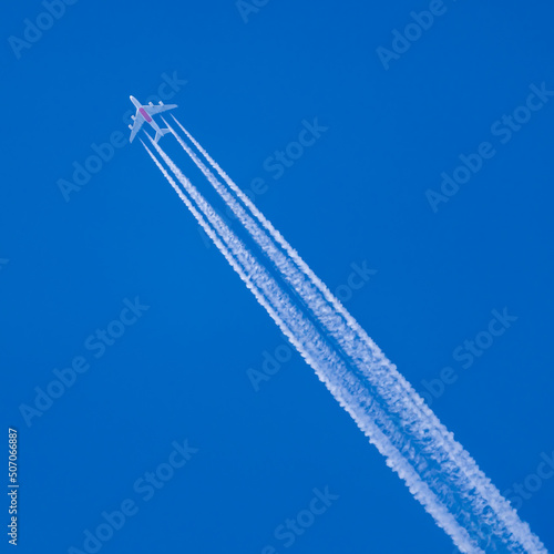 Flying plane trail in blue sky
