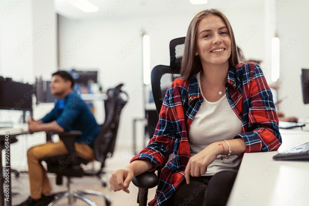Casual business woman working on desktop computer in modern open plan startup office interior. Selective focus 