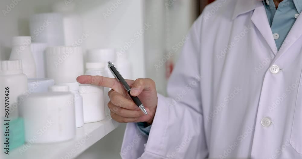pharmacist checking list documents medicine on shelf in drugstore Thailand 4k video
