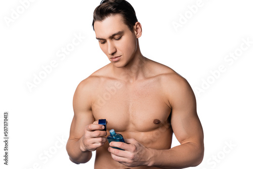 brunette man with muscular body opening perfume isolated on white.