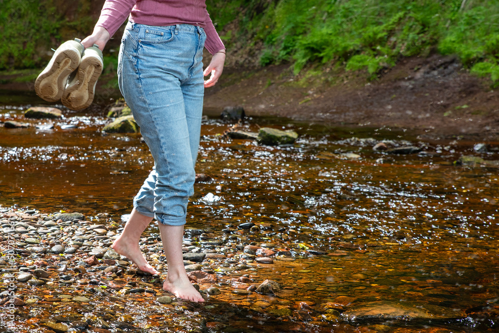 Woman Walking Barefoot In Mountain River. Finnich Glen.The Devil’s Pulpit in Scotland. UK. Woman Walking Barefoot In Mountain River. Finnich Glen.The Devil’s Pulpit in Scotland. UK.